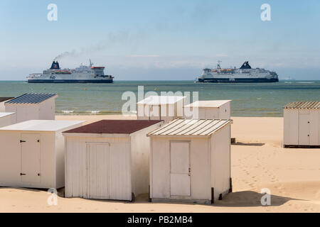 Calais, Frankreich - 19. Juni 2018: Beach Cabins und DFDS/P&O Cross Channel Fähren. Stockfoto