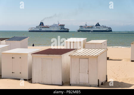 Calais, Frankreich - 19. Juni 2018: Beach Cabins und DFDS/P&O Cross Channel Fähren. Stockfoto