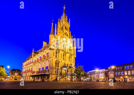 Monumentalen gotischen Rathaus der historische Stadt Gouda Square, mit Lichtern in der Dämmerung beleuchtet unter einem dunkelblauen Himmel. Einer der ältesten gotischen c Stockfoto