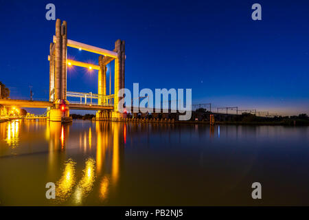 Modernes Design Vertikallift Eisenbahnbrücke Hoge Gouwespoorbrug in Gouda, Niederlande über den Fluss Gouwe während des Sonnenuntergangs. Stockfoto