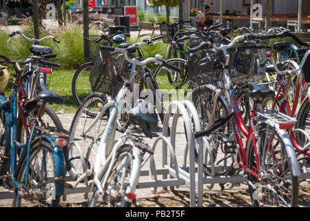 SZEGED, UNGARN - Juni 3, 2018: Fahrräder raks voller Bikes von communters in der Nähe von Szeged Markt geparkt. Ungarn ist berühmt für seine riesigen Fahrräder Stockfoto