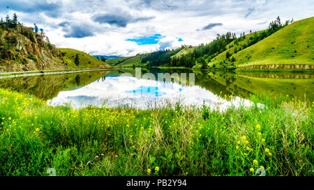 Blauer Himmel, Wolken und die umliegenden Berge im Wasser von Trapp See widerspiegelt, entlang der Autobahn 5 zwischen Kamloops und Merritt im schönen BC Kanada Stockfoto