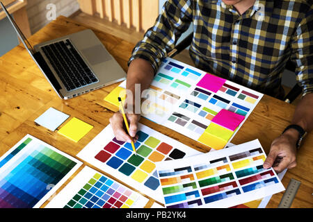 Grafik Designer wählen Sie Farben aus der Farbkarte Bands proben für Design. Designer grafische Kreativität arbeit Konzept. Stockfoto