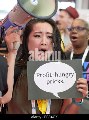 Amsterdam, Niederlande, 25. Juli 2018: Jennifer Ho aus Thailand hält ein Schild in einem Juli 25 Demonstration in der Ausstellungshalle der Internationalen AIDS-Konferenz 2018 in Amsterdam, Niederlande. Ho und andere vorübergehend beschlagnahmt die Exponate von einigen pharmazeutischen Unternehmen, denen er vorwarf, nicht mit einer Ernte exorbitanten Gewinne aus einem langsamen und oft unzureichend AIDS-Antwort. Credit: Paul Jeffrey/Alamy leben Nachrichten Stockfoto