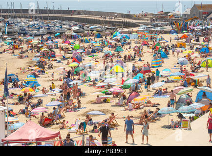 Lyme Regis, Dorset, Großbritannien. 26. Juli 2018. UK Wetter: Sonnenschein und blauer Himmel in Lyme Regis. Familien und Sonnenanbeter in Scharen zu den malerischen Strand im Badeort von Lyme Regis die glühend heiße Sonne wieder zu genießen heute Nachmittag als das VEREINIGTE KÖNIGREICH schmilzt. Die Temperaturen sind wieder auf dem Vormarsch mit Freitag den heißesten Tag auf Aufzeichnung zu sein. Credit: Celia McMahon/Alamy leben Nachrichten Stockfoto