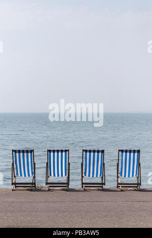 Vier unbesetzt im traditionellen Stil Liegestühle am Meer in Westcliff-on-Sea während der Hitzewelle im Juli 2018 Stockfoto