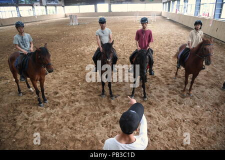 (180726) - NANCHANG, 26. Juli 2018 (Xinhua) - Huang Wanpeng, ein Schüler von Sonnenschein, Reitschule, besucht eine Trainingseinheit mit seinen Mitschülern in Yihuang Grafschaft von Fuzhou, East China's Jiangxi Province, 23. Mai 2018. Pferdesport nie in Yihuang, eine landwirtschaftliche Grafschaft in der ostchinesischen Provinz Jiangxi gehört, bis Sonnenschein Reitschule begann Recruiting ländliche Jugendliche im Jahr 2015. Bisher haben die meisten der 90 Schüler arbeiten oder angehende im Pferd zur Arbeit reiten Vereine in Chinas größten Städten wie Peking, Shanghai und Hangzhou. (Xinhua / Zhou Mi) (lmm) Stockfoto