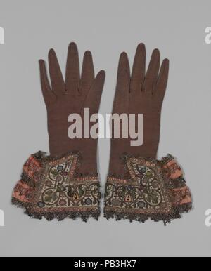 Paar handschuhe. Kultur: Britische. Abmessungen: L 13 1/2x W. 6 1/2 Zoll (34,3 x 16,5 cm). Datum: 1620s. Die reichen aus braunem Leder dieser Handschuhe ist ungewöhnlich; die meisten Überlebenden Handschuhe aus dem siebzehnten Jahrhundert sind heller in der Farbe. Aber die Motive gestickt auf der Stulpen --pea Pods und Blüten - waren durchaus üblich während der Periode. Pea pods wurden oft mit romantischer Liebe. Sie finden sich auf beiden Haushalt Möbel und anderes Zubehör des Kleides, wie eine Frau von ungefähr zum gleichen Zeitpunkt in der Sammlung des Museums (23.170.1.). Museum: Metropolitan Museum of Art, New York, Stockfoto