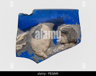 Glas cameo cup Fragment. Kultur: Roman. Abmessungen: Insgesamt: 1 1/4 x 1 7/16 in. (3,2 x 3,7 cm). Datum: Ende des 1. Jh. B.C - Anfang des 1. Jh. N.CHR.. Transluzente Kobaltblau mit Overlays in opak weiß und transparentem dunkel Blau. Vertikale Felge mit auch Lippe und Abgeschrägten inneren Rand; zylindrische Körper mit leicht konvex geschwungene Seite. Im Inneren, horizontale Nut unter Rim; an der Außenseite, auch weibliche Figur in Weiß, wahrscheinlich stehen, nach links weist, und vor ihr, in beiden Händen eine große ovale Objekt, vielleicht eine Trommel oder ein Tamburin; ihr Kopf ist im Profil mit Ihrem Haar Stockfoto