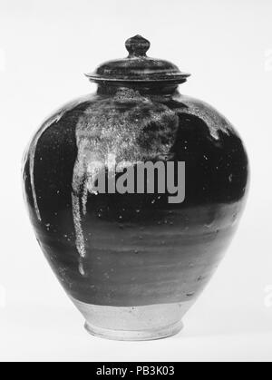 Überdachte Jar. Kultur: China. Abmessungen: H.12 cm. (31,8 cm); W. 8 7/8 in. (22,5 cm). Datum: 8. Von der Manipulation von Kupfer Stickoxide während des Feuern, schwarz und dunkelbraun Glasuren zuerst in North China entwickelt abgeleitet, im letzten Teil der Tang Dynastie. Waren mit solchen Glasuren wie Haushaltswaren serviert und wurde während der zehnten, elften und zwölften Jahrhundert. Museum: Metropolitan Museum of Art, New York, USA. Stockfoto