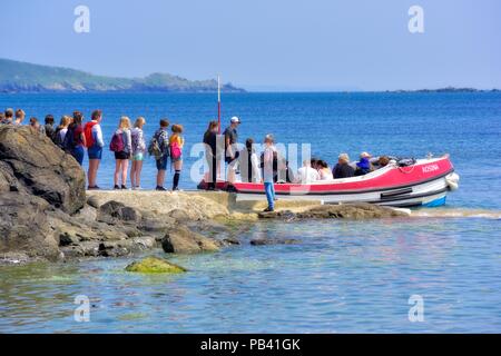 Studenten in der Warteschlange für die Bootsfahrt zu den St Michael Berg, Karrek Loos yn Koos, Marazion, Cornwall, England, Großbritannien Stockfoto