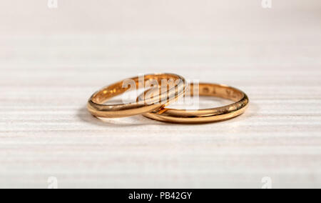 Ein paar goldene Hochzeit Ringe auf weißem Holz- Hintergrund Stockfoto