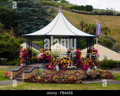 Sommer Bettwäsche Blumen bedeck der Viktorianischen Musikpavillon in Runnymede Gärten, Ilfracombe, Devon, Großbritannien Stockfoto