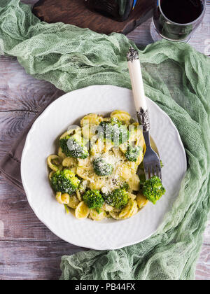 Pasta Orecchiette mit Brokkoli in Weiß Teller auf Holztisch. Einfaches Rezept für das Mittagessen. Stockfoto