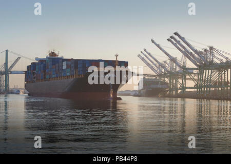 Containerschiff, KOTA CAHAYA, vorbei durch die Los Angeles wichtigste Kanal, als Sie den Hafen fährt von Los Angeles bei Sonnenaufgang. Kalifornien, USA. Stockfoto