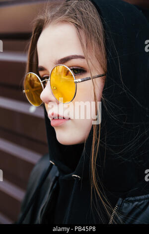 Fashion kid Konzept - Elegante kleine Mädchen mit schwarzen legere Kleidung und Sonnenbrillen posing Sommer in der Stadt Stockfoto