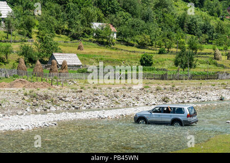 Ein Auto in der Furt des Flusses Grencars Vermosh, der nördlichste Dorf in Albanien, knapp unterhalb der Grenze mit Montinegro. Albanien. Stockfoto