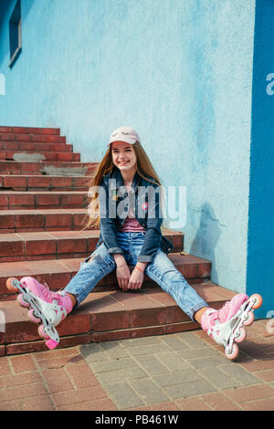 Kleine hübsche Mädchen auf Rollschuhen in der Stadt Stockfoto