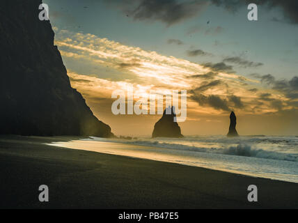 Sonnenaufgang am berühmten schwarzen Sandstrand Strand Reynisfjara in Island. Windigen Morgen. Ocean Waves. Bunte Himmel. Morgen Sonnenuntergang. Stockfoto