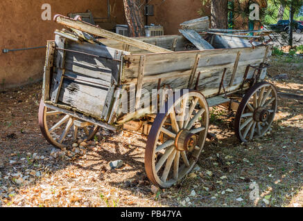 TAOS, NM, USA-6 Juli 18: Eine alte Farm Wagen setzt außerhalb der rote Pfeil Emporium auf dem Landweg Schaffell Ranch in El Prado, Taos, NM. Stockfoto