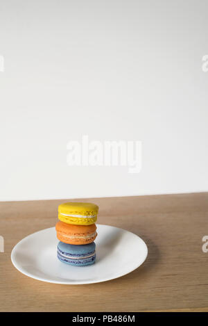 Macarons Set mit drei Sitzen in der hellen Sonne auf einer minimalen Hintergrund Stockfoto