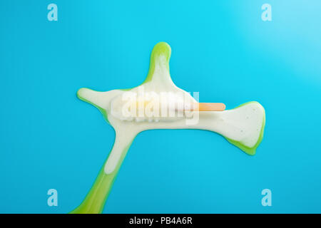 Gelbe Popsicle in einem Schmelzvorgang auf blauem Hintergrund Stockfoto