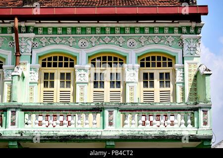 Traditionelle Singapur Peranakan oder Straits Chinesischen shop Haus mit Bogenfenster, antiken creme Fensterläden aus Holz und grüne Fassade in Geylang Stockfoto