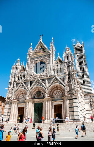 Die Menschen die vor der gotischen Kathedrale Santa Maria Assunta, in der mittelalterlichen Stadt Siena, Toskana, Italien Stockfoto