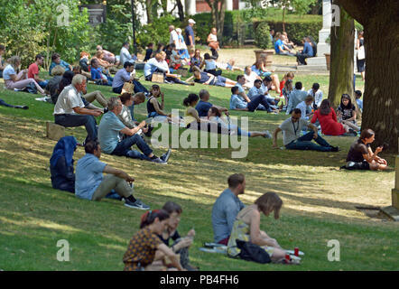 Touristen und Mitarbeiter gleichermaßen, versuchen einige Schatten in der Victoria Embankment Gardens in London zu finden, da die Temperaturen zu erwarten sind 35 C heute getroffen, als die Hitzewelle in Großbritannien fort. Stockfoto