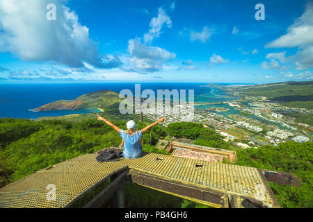 Glückliche Frau genießen an der Oberseite des Koko Head Krater Trail. Luftaufnahme von Hanauma Bay, Diamond Head und Honolulu, Oahu, Hawaii, USA. Hawaiian Wandern in der Natur Landschaft. Weibliche Wanderer mit erhobenen Armen Stockfoto