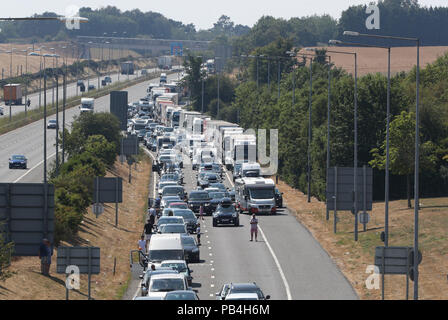 Warteschlangen für den Eurotunnel in Folkestone, Kent, zurück Ausdehnung in Richtung Autobahn M20, die als Fahrgäste mit der Cross-Channel Services wurden Verzögerungen von bis zu fünf Stunden gewarnt, nachdem Klimaanlagen in den Zügen inmitten der heißen Temperaturen ist fehlgeschlagen. Stockfoto