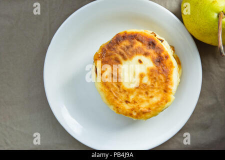 Stapel von hausgemachten köstlichen Mascarpone Pfannkuchen Pastetchen auf weiße Platte Dunkel Grau Baumwolle Serviette. Birne. Im rustikalen Stil der Provence Küche Interieur. Mornin Stockfoto