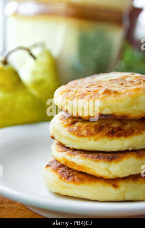 Stapel von hausgemachten köstlichen Mascarpone Pfannkuchen Pastetchen auf weiße Platte Dunkel Grau Baumwolle Serviette. Birne. Rustikale Küche Interieur. Frühstück am Morgen. Co Stockfoto