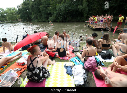 Menschen Sonnenbaden an der gemischten Badeteich in Hampstead Heath, London, als hitzewelle Bedingungen über viel von England weiter. Stockfoto