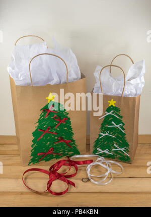 Zwei Papier Geschenktüten für Weihnachten dekoriert und für entlang, mit roten und weißen Bandes bereit Stockfoto