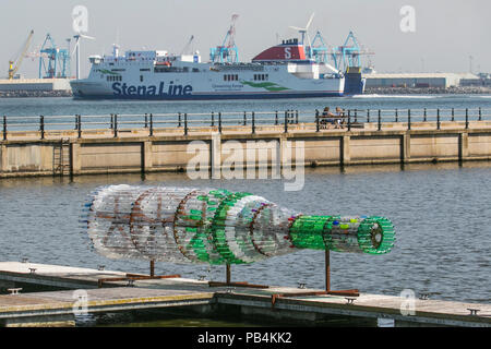 Große übergroße Getränke Flaschenskulptur aus recyceltem, wiederverwendetem, Upcycling-Kunststoff New Brighton, Wallasey. Öffentliche Kunstwerke von Kunststoff-Container aus gebrauchten Flaschen gebaut. Künstler Lulu Quinn schöne und zum Nachdenken anregende „Message in a Bottle“-Upcycling-Flaschenskulptur in Position am Marine Lake. Das 8 m lange Kunstwerk wurde aus 1,500 gebrauchten Getränkeflaschen aus Kunststoff gefertigt, die aus der ganzen Region gesammelt wurden. Stockfoto