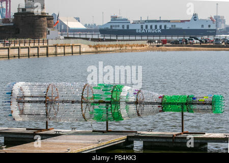 Große übergroße Getränke Flaschenskulptur aus recyceltem, wiederverwendetem, Upcycling-Kunststoff New Brighton, Wallasey. Öffentliche Kunstwerke von Kunststoff-Container aus gebrauchten Flaschen gebaut. Künstler Lulu Quinn schöne und zum Nachdenken anregende „Message in a Bottle“-Upcycling-Flaschenskulptur in Position am Marine Lake. Das 8 m lange Kunstwerk wurde aus 1,500 gebrauchten Getränkeflaschen aus Kunststoff gefertigt, die aus der ganzen Region gesammelt wurden. Stockfoto