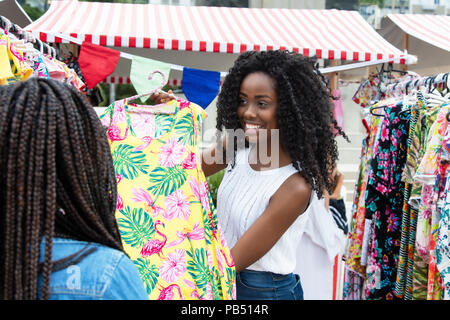 Afrikanische amerikanische markt anbieter Kleidung präsentieren Stockfoto