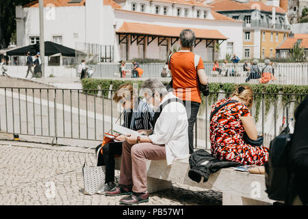 Portugal, Lissabon, 01. Mai 2018: Reifes Paar auf einer Bank sitzen und beobachten eine Karte für weitere Reisen. Stockfoto