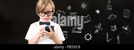 School Boy holding Taschenrechner und Bildung zeichnen auf blackboard für Schule Stockfoto