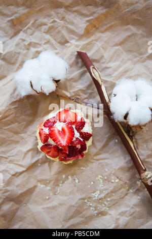 Schöne Muffin mit frischen Erdbeeren liegt auf Handwerk Papier, close-up Stockfoto