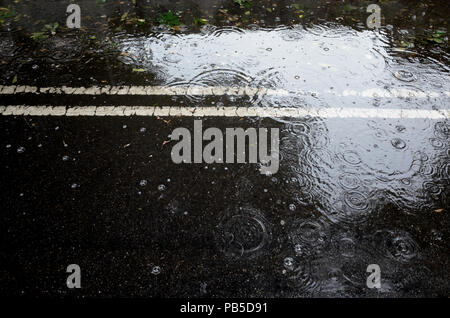 Regenwetter Pfütze. City Road schlechtes Wetter Stockfoto