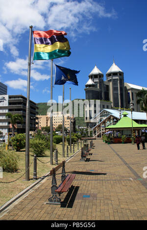 Flagge von Mauritius fliegen in den Wind an den Palmen gesäumten Hauptplatz vor dem Caudan Waterfront in Port Louis, Mauritius Stockfoto