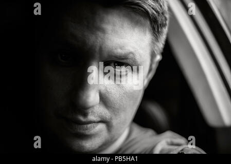 Porträt eines Mannes in einem Auto close-up in Schwarz und Weiß gehalten. Schwarzweiß-Foto. Stockfoto