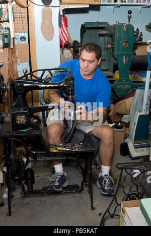 St. Paul, Minnesota. Lokale Schuster, die aus dem Iran emigrierte Arbeiten auf einem Schuh auf der Nähmaschine in seinem Shop für einen Kunden. Stockfoto