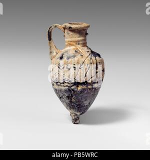 Glas amphoriskos (Parfüm Flasche). Kultur: Griechisch, Östliches Mittelmeer oder Italienisch. Abmessungen: H.: 2 15/16 in. (7,5 cm). Datum: 4. Jahrhundert v. Chr.. Transluzente Kobaltblau, mit Griff und Base-Knopf gleicher Farbe; Trail in unsicheren Farbe. Auch als horizontale Rim mit abgerundeten äußere Lippe; zylindrische Hals, schräge Schulter; ovoide Körper, verjüngt sich nach unten; base-Knopf angewendet; Strap Griff in einen großen Block an Schulter, ausgearbeitet und leicht nach außen, dann in Kurven und drückte auf den Hals unter Rim. Trail am Hals unterhalb von Rim und die Wunde, die in der Spirale, über die Schulter gezogen und dann zu Stockfoto