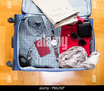 Öffnen traveler Tasche mit Kleidung und Accessoires. Reisen und Urlaub Konzept. Stockfoto