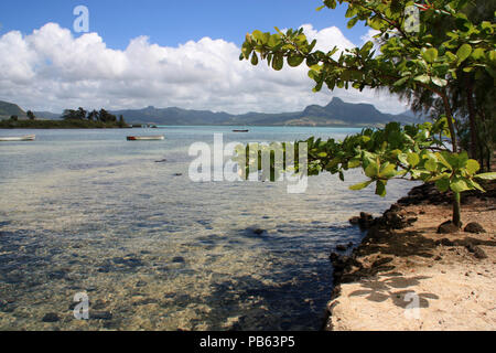 Flacher, Türkis, kristallklarem Wasser an einer Lagune in der Nähe von Mahebourg, Mauritius mit der vulkanischen Landschaft im Hintergrund Stockfoto