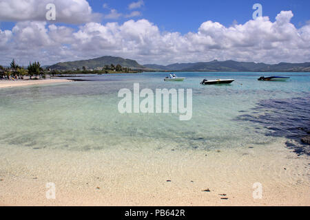 Motorboote an einer Lagune mit flachem, Türkis, kristallklares Wasser vor einem wunderschönen Strand auf Mauritius verankert Stockfoto