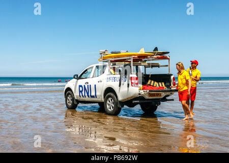 Zwei RNLI Lifeguards und Fahrzeug am Strand von Westward Ho!, Devon, Großbritannien Stockfoto